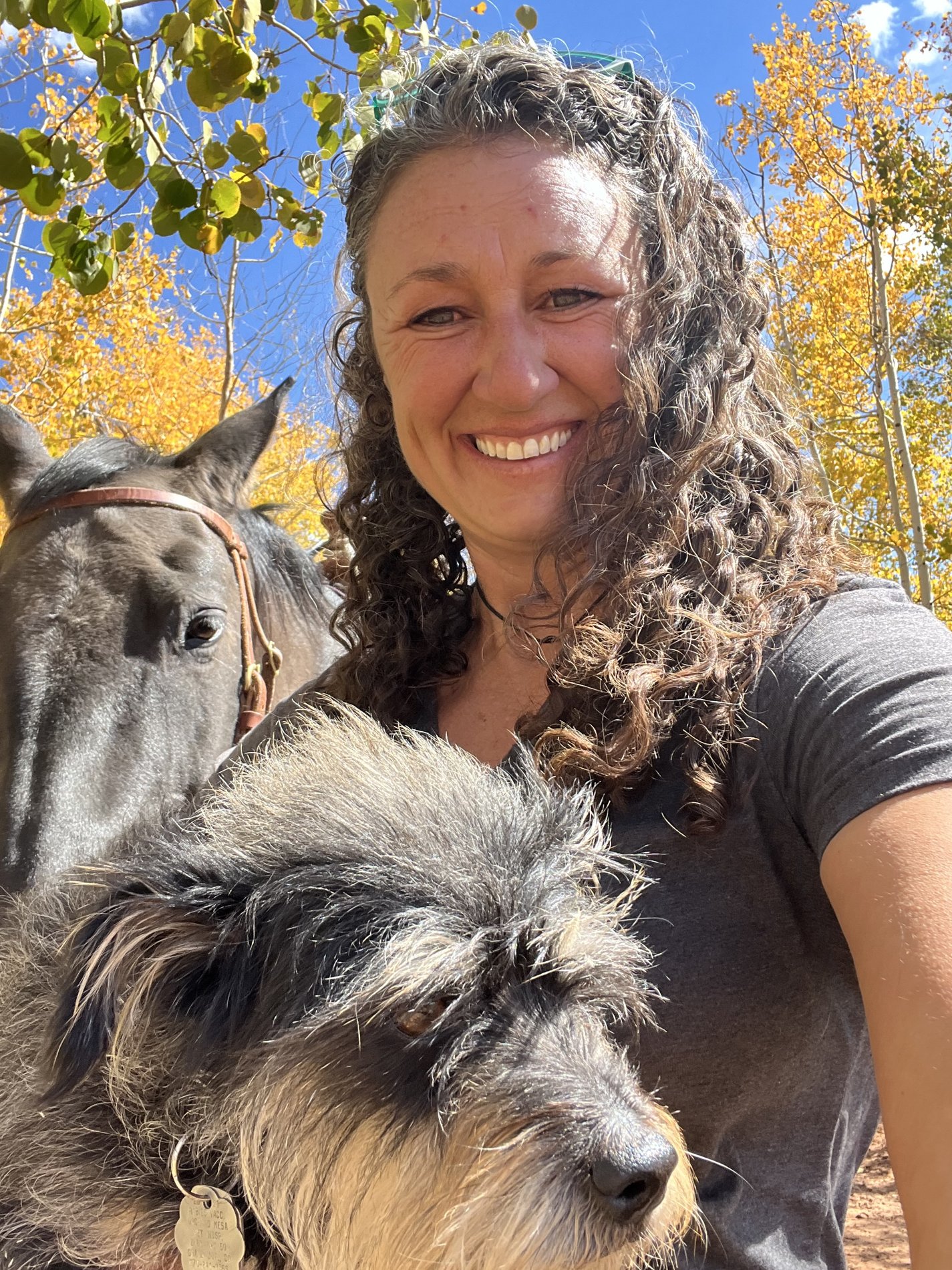 Amy with Lulu and Gunny surrounded by fall leaves